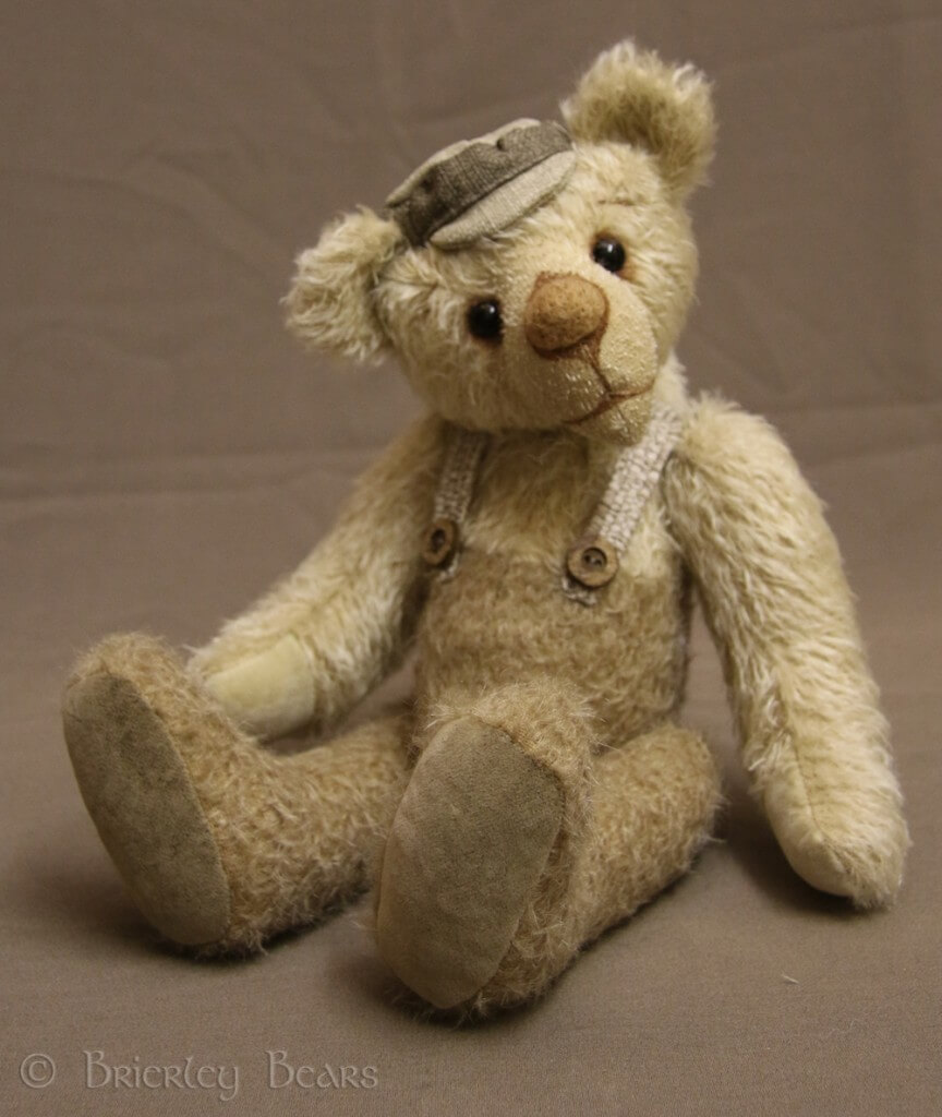 George - a traditional bear made from mohair with a flat cap and braces.