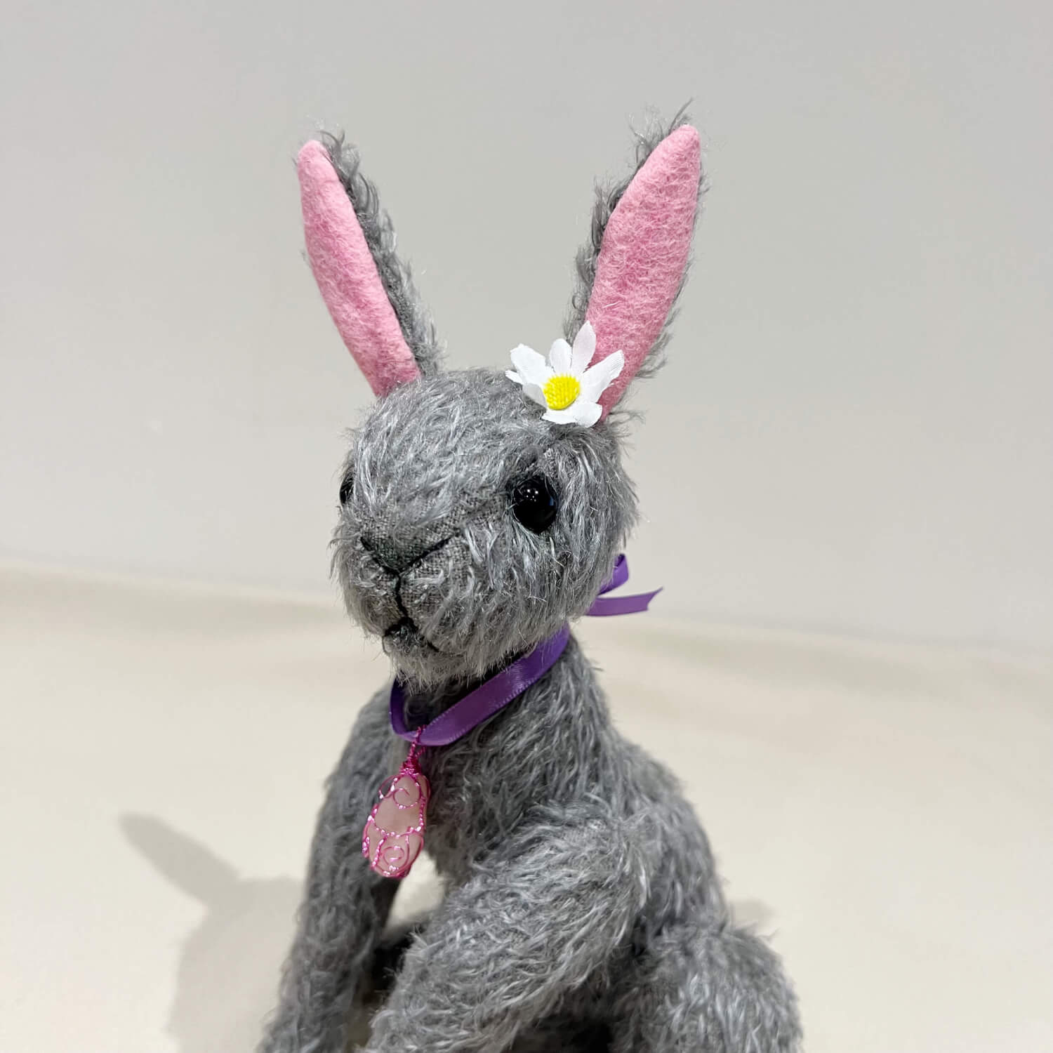 Primrose one‑of‑a‑kind mohair handmade hare. Grey with pink inner ears and a daisy in ear and rose quartz pendant by Brierley Bears. Head.
